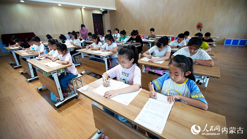作業(yè)輔導(dǎo)中，孩子們十分安靜地認(rèn)真完成暑假作業(yè)。李強(qiáng)攝