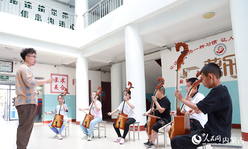 孩子們饒有興趣地學(xué)習(xí)拉馬頭琴。陳先達(dá)攝