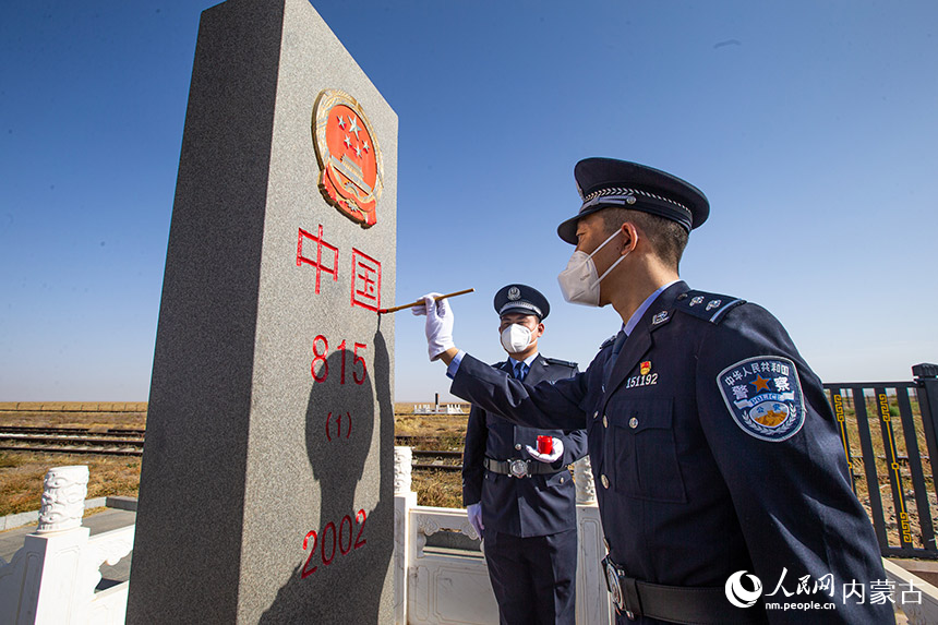 內(nèi)蒙古出入境邊防檢查總站二連出入境邊防檢查站執(zhí)勤民警為中蒙邊境“815號(hào)界碑”描紅。胡富國(guó)攝
