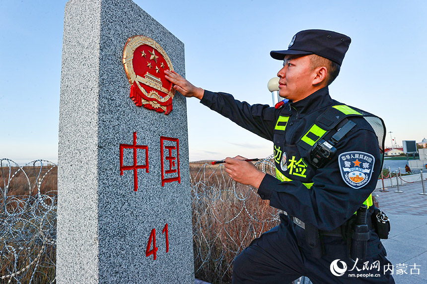 內(nèi)蒙古邊檢總站滿洲里邊檢站民警擦拭中俄邊境41號界碑。盧兵兵攝