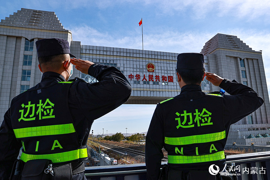 內(nèi)蒙古邊檢總站滿洲里邊檢站執(zhí)勤民警面向國門敬禮，表達(dá)對祖國的深情祝福。盧兵兵攝