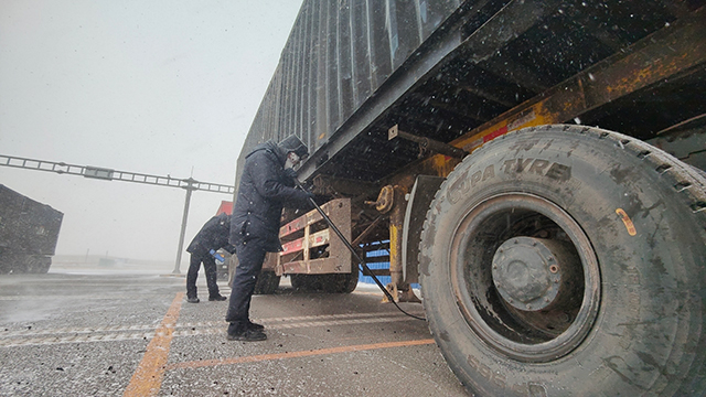 民警頂風(fēng)冒雪，查驗(yàn)出入境車輛。