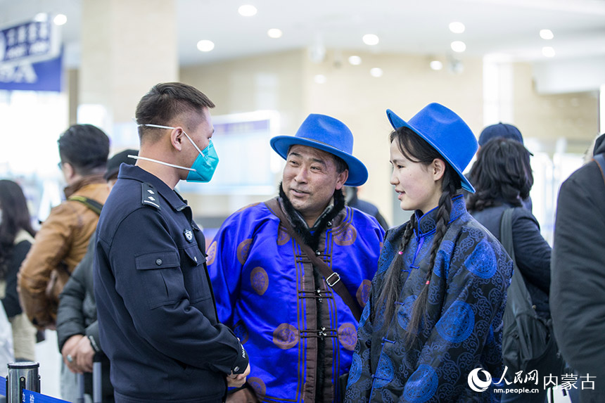 二連出入境邊防檢查站執(zhí)勤民警為旅客提供通關咨詢。郭鵬杰攝