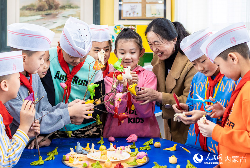 內(nèi)蒙古呼和浩特市玉泉區(qū)五塔寺東街小學(xué)學(xué)生將面塑寒燕懸掛枝頭，寓意春燕歸來。丁根厚攝