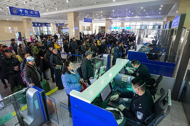 圖1：二連出入境邊防檢查站執(zhí)勤民警為旅客辦理通關(guān)手續(xù)。