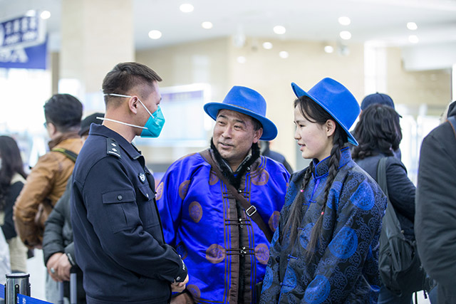 圖3：二連出入境邊防檢查站執(zhí)勤民警為旅客提供通關(guān)咨詢。