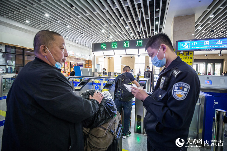 二連出入境邊防檢查站執(zhí)勤民警為旅客提供通關咨詢引導。胡富國攝