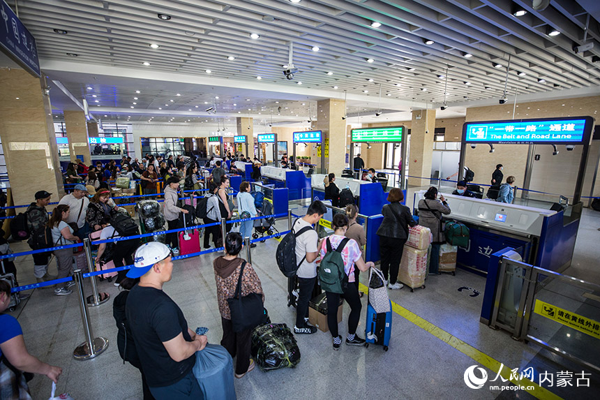 二連出入境邊防檢查站執(zhí)勤民警為旅客辦理通關(guān)手續(xù)。胡富國攝