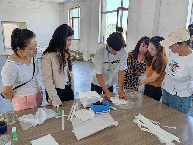 零工市場工作人員向零工演示紙圍裙的做法。云美玲攝