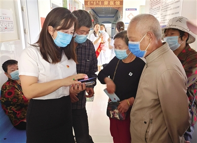 　　阿拉善盟孿井灘生態(tài)移民示范區(qū)圍繞打通為民服務(wù)“最后一米”，傾力打造“小駝幫辦”手機(jī)小程序特色服務(wù)。圖為黨建聯(lián)盟志愿服務(wù)隊成員幫助老人進(jìn)行線上預(yù)約掛號。李雅蓉 攝
