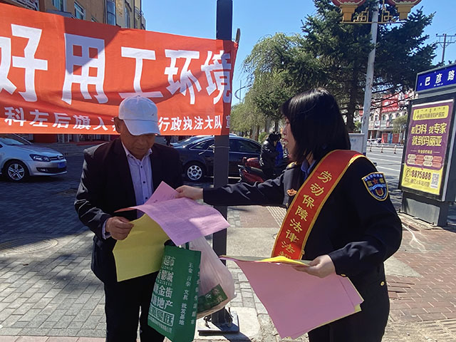 工作人員為群眾發(fā)放勞動(dòng)保障法律法規(guī)宣傳單。白薇攝