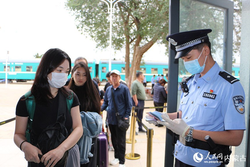 二連出入境邊防檢查站執(zhí)勤民警查驗(yàn)旅客出入境證件。劉劍輝攝