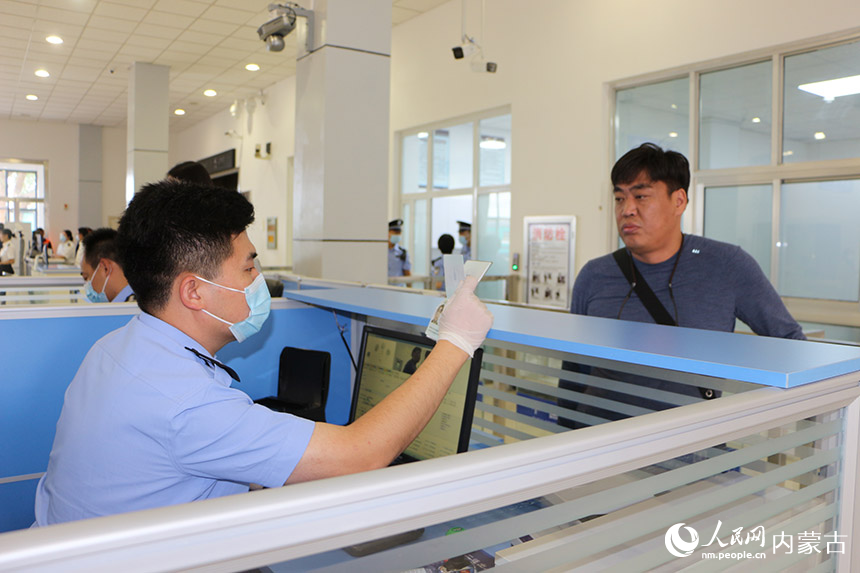 二連出入境邊防檢查站執(zhí)勤民警為旅客辦理通關(guān)手續(xù)。劉劍輝攝