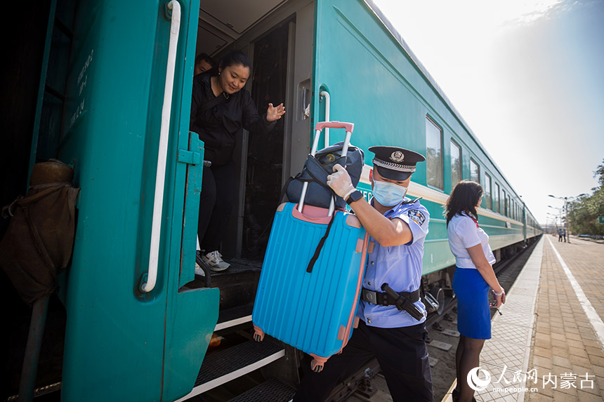 二連出入境邊防檢查站執(zhí)勤民警幫助旅客提拿行李。郭鵬杰攝
