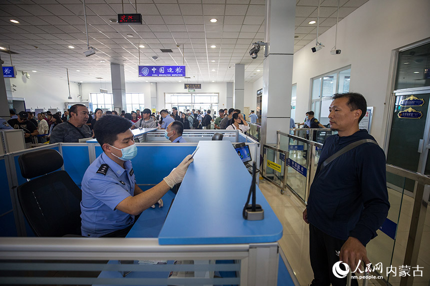 二連出入境邊防檢查站執(zhí)勤民警為參加中蒙博覽會的旅客辦理入境通關(guān)手續(xù)。郭鵬杰攝