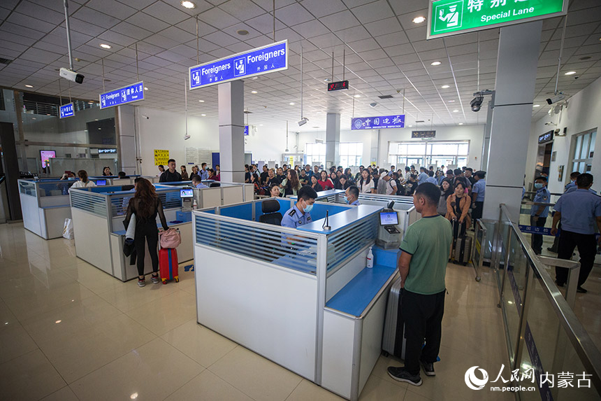 二連出入境邊防檢查站執(zhí)勤民警為參加中蒙博覽會的旅客辦理入境通關手續(xù)。郭鵬杰攝