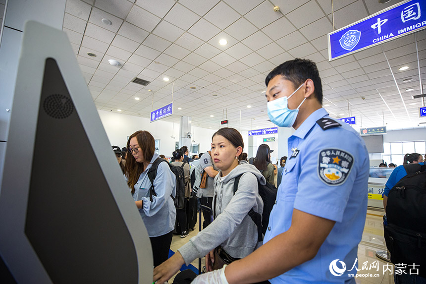 二連出入境邊防檢查站執(zhí)勤民警協(xié)助旅客辦理通關手續(xù)。郭鵬杰攝