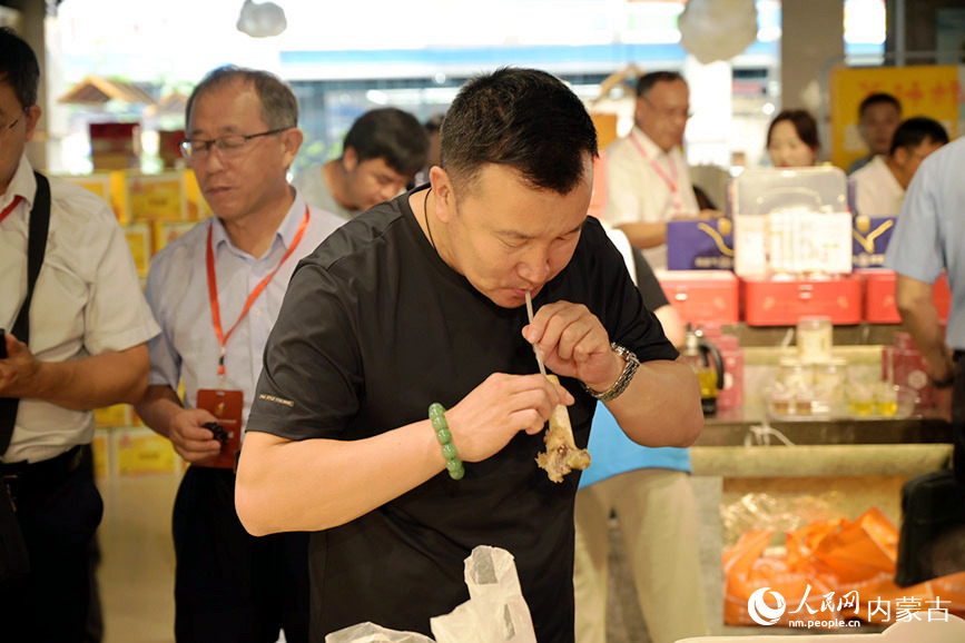 游客在展區(qū)品嘗巴彥淖爾美食。人民網(wǎng) 寇雅楠攝