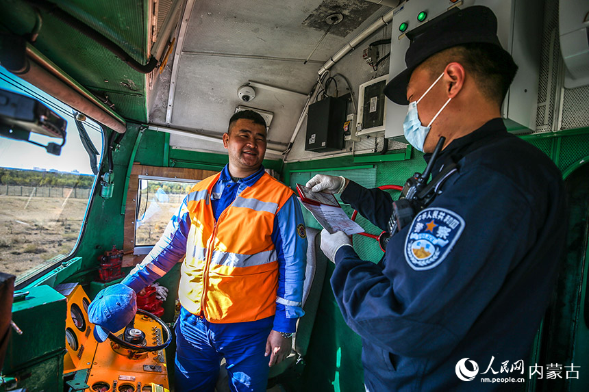 二連出入境邊防檢查站執(zhí)勤民警查驗(yàn)列車員工出入境證件。郭鵬杰攝