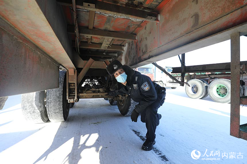 二連出入境邊防檢查站執(zhí)勤民警對(duì)通關(guān)貨車進(jìn)行車體檢查。郭鵬杰攝