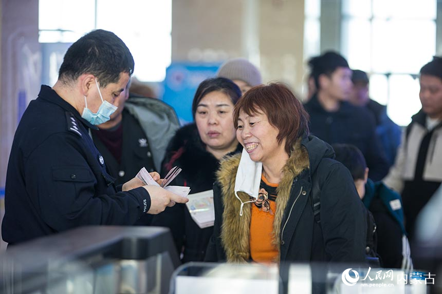二連出入境邊防檢查站移民管理警察為旅客辦理通關(guān)手續(xù)。郭鵬杰攝
