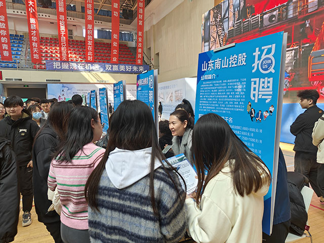 企業(yè)工作人員向求職高校生介紹崗位要求、薪資待遇。