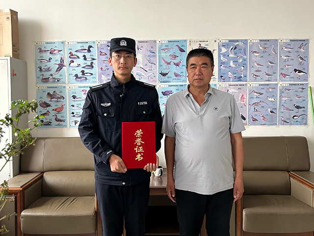 救助站工作人員為民警頒發(fā)榮譽(yù)證書。