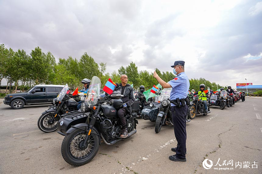 二連出入境邊防檢查站移民管理警察查驗(yàn)?zāi)ν熊囎择{旅游團(tuán)成員通關(guān)證件。楊金燁攝