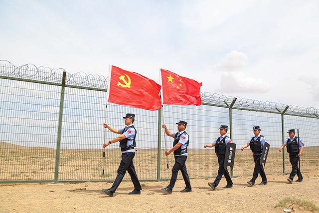 6月29日，內(nèi)蒙古滿都拉邊境派出所民警擎旗巡邊，迎接黨的生日（張宇攝）