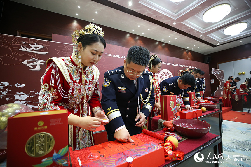 一對(duì)新人在婚禮書(shū)上按下手印。郭鵬杰攝