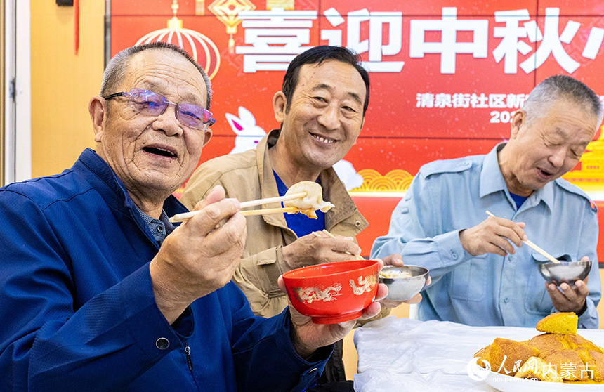 內(nèi)蒙古呼和浩特市玉泉區(qū)清泉街社區(qū)居民在開心地品嘗餃子。丁根厚攝