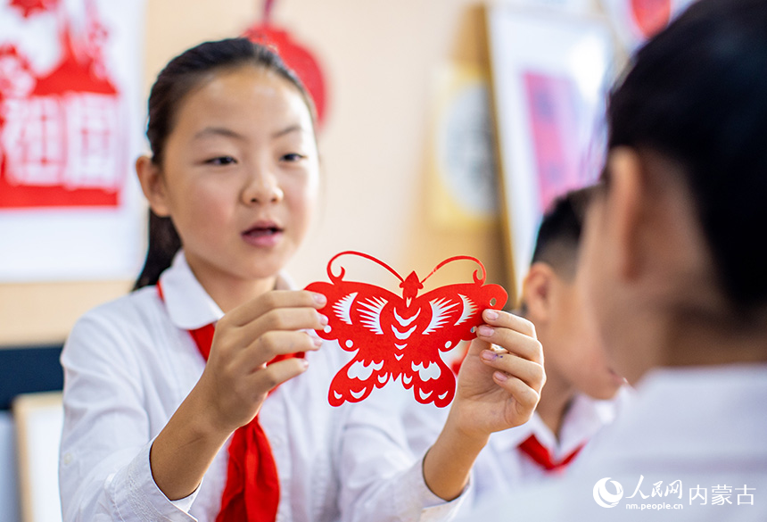 呼和浩特市玉泉區(qū)恒昌店巷小學五里營校區(qū)的學生在制作迎國慶主題的剪紙作品。丁根厚攝