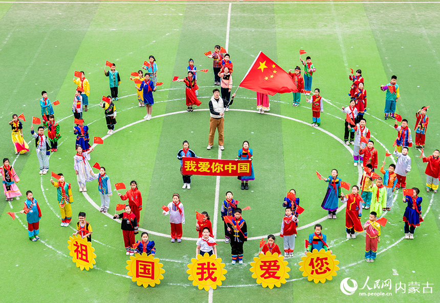 呼和浩特市玉泉區(qū)南柴火市街小學(xué)師生同唱歌曲《歌唱祖國》，表達(dá)對祖國的愛。丁根厚攝