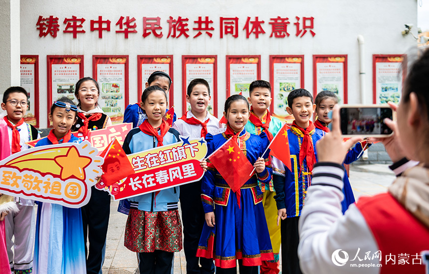 呼和浩特市玉泉區(qū)南柴火市街小學師生在“童心頌祖國 歡歌迎國慶”主題活動現場打卡拍照。丁根厚攝