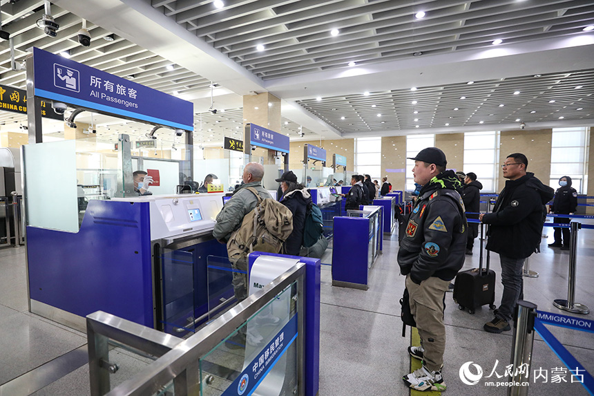二連出入境邊防檢查站移民管理警察為旅客辦理通關(guān)手續(xù)。郭鵬杰攝