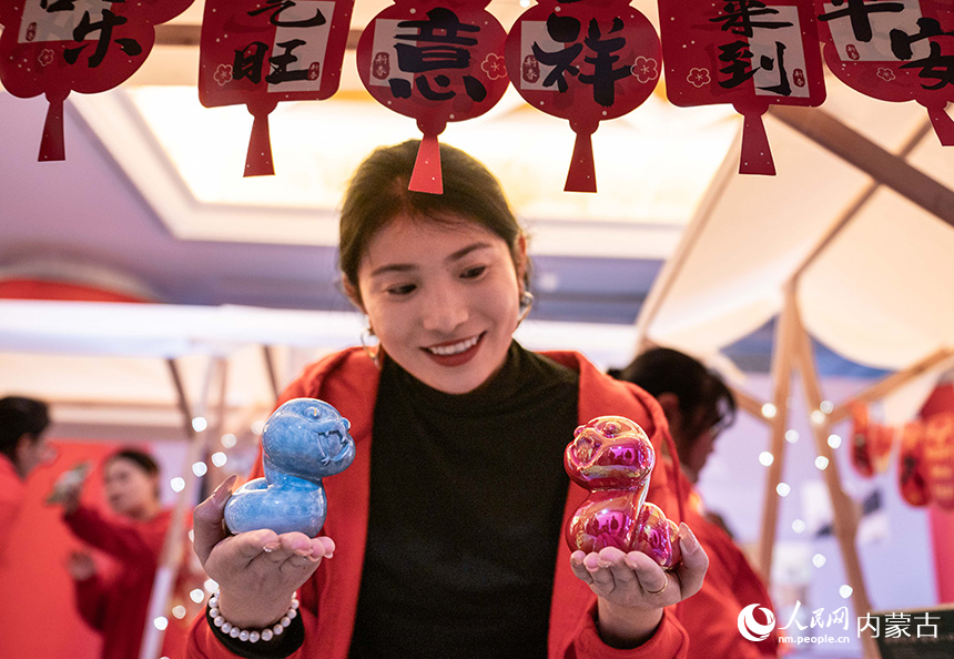 呼和浩特博物館，工作人員在景德鎮(zhèn)中國陶瓷博物館展位上展示生肖蛇文創(chuàng)產(chǎn)品。丁根厚攝