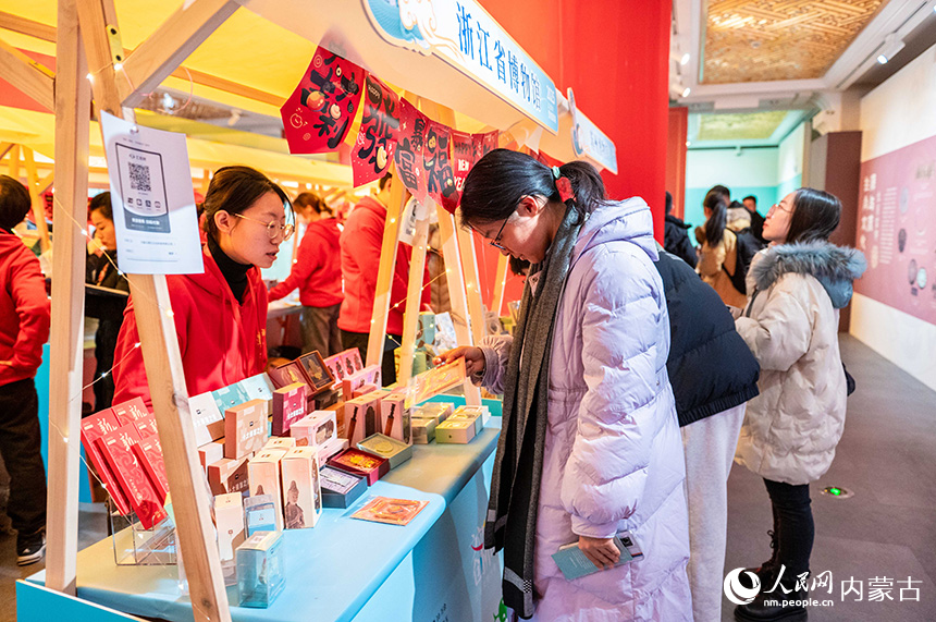 呼和浩特博物館，參觀者在浙江省博物館展位上挑選文創(chuàng)產(chǎn)品。丁根厚攝