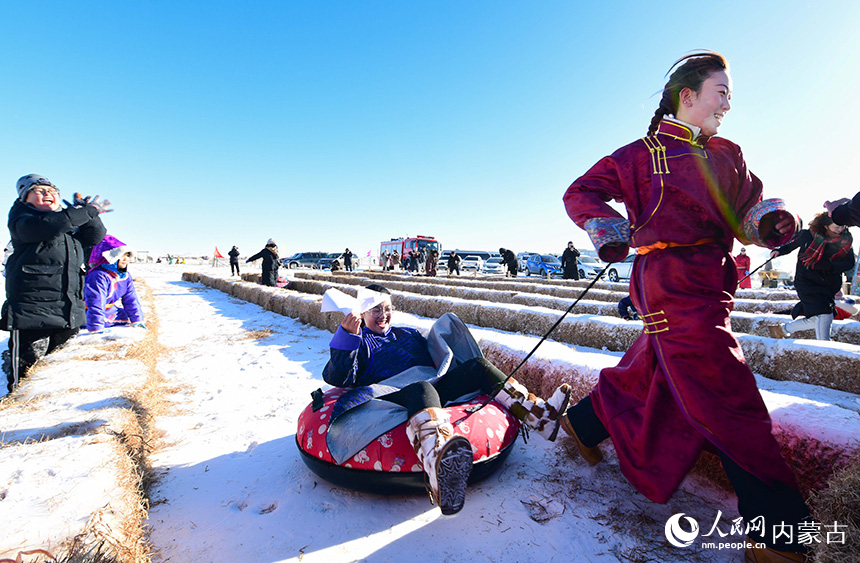 游客參加拉雪圈比賽。王正攝