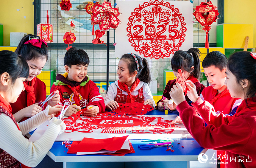 呼和浩特市玉泉區(qū)五塔寺東街小學(xué)學(xué)生在制作迎新年剪紙作品。丁根厚攝