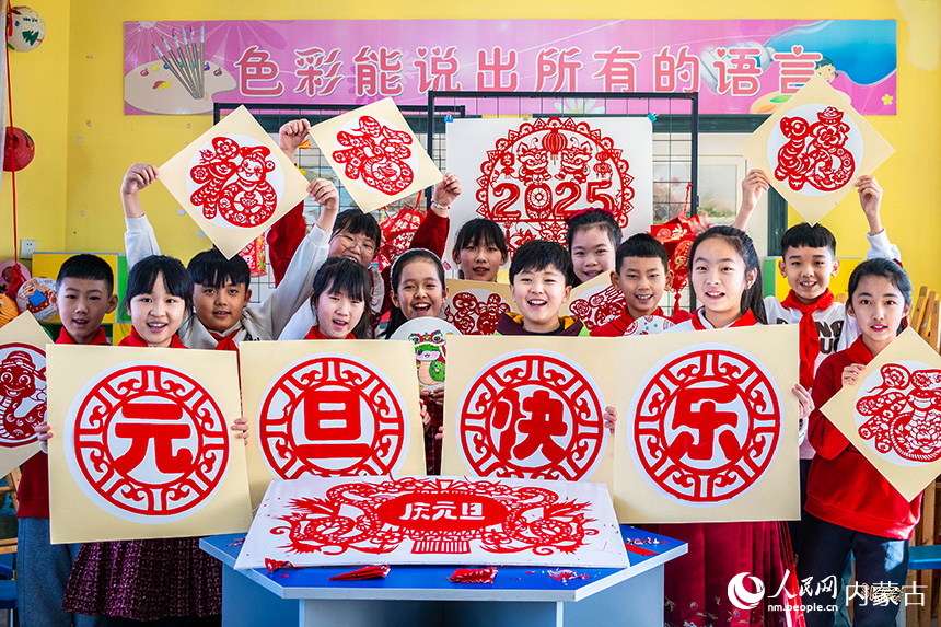 呼和浩特市玉泉區(qū)五塔寺東街小學學生手持繪畫、剪紙作品，歡喜迎新年。丁根厚攝