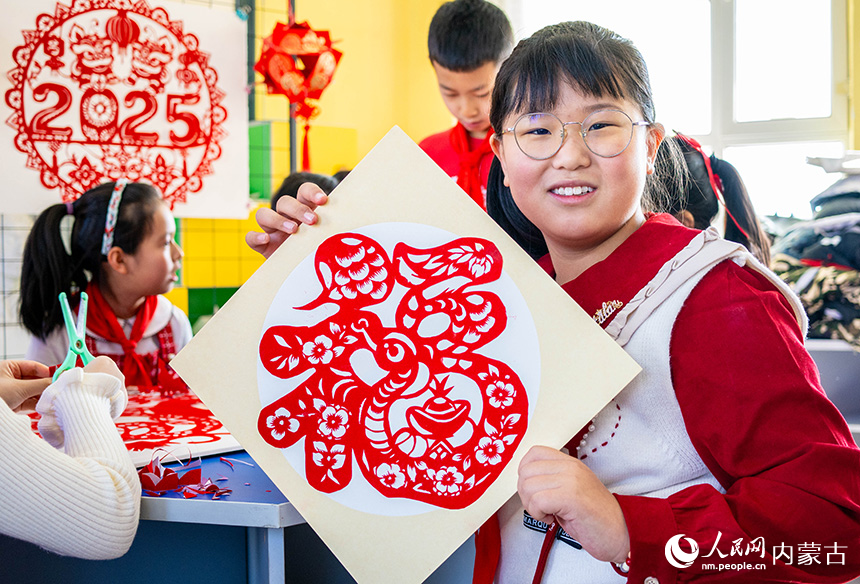 呼和浩特市玉泉區(qū)五塔寺東街小學(xué)學(xué)生展示繪制的福字剪紙作品。丁根厚攝
