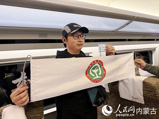 北京理工大學(xué)鐵路文化協(xié)會的學(xué)生石興億與首發(fā)列車紀(jì)念車票合影。人民網(wǎng)記者 寇雅楠攝