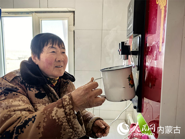 牧民娜仁花用電熱水器接熱水。