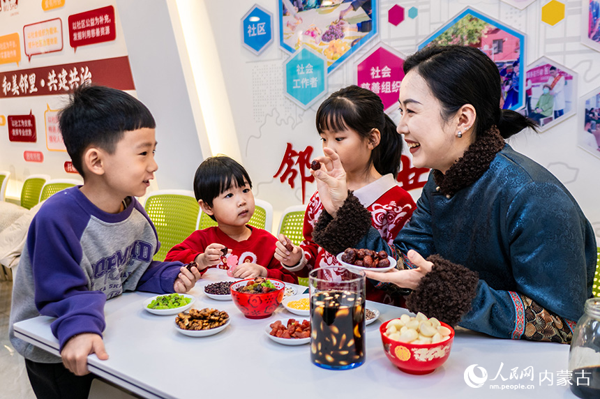 呼和浩特市玉泉區(qū)清泉街社區(qū)小朋友在臘八節(jié)活動現(xiàn)場學習了解“臘八”習俗。丁根厚攝