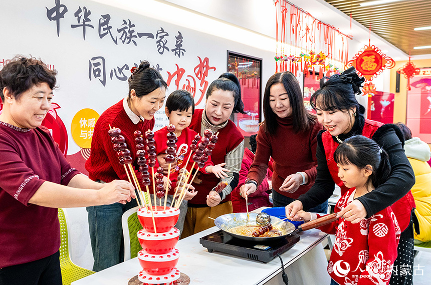 呼和浩特市玉泉區(qū)清泉街社區(qū)居民在臘八節(jié)活動現(xiàn)場制作糖葫蘆。丁根厚攝