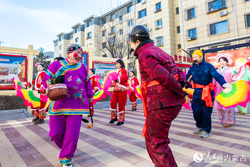 呼和浩特市玉泉區(qū)清泉街社區(qū)志愿者和居民在臘八節(jié)活動(dòng)現(xiàn)場(chǎng)表演社火。丁根厚攝