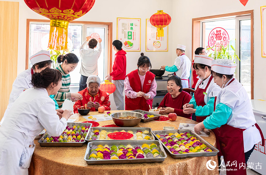 1月20日，志愿者與老人們?cè)诤艉秃铺厥杏袢獏^(qū)民政局迎新春主題活動(dòng)現(xiàn)場(chǎng)一起包餃子。丁根厚攝