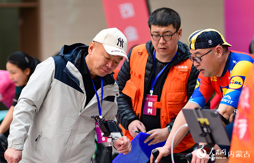 裁判員在全民健身體驗(yàn)組5公里項(xiàng)目比賽中記錄參賽選手成績(jī)。王正攝