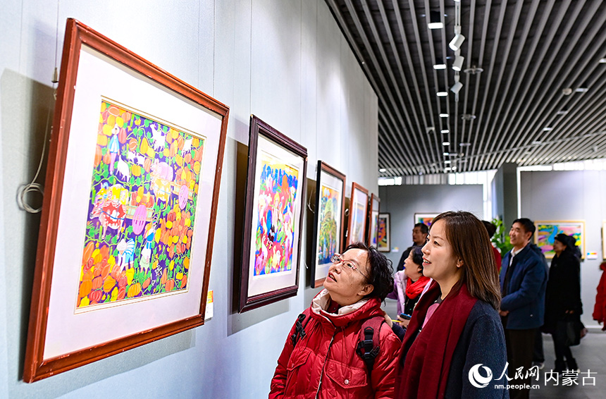 觀眾在鄂爾多斯市文化館觀賞云南農(nóng)民畫(huà)展。王正攝
