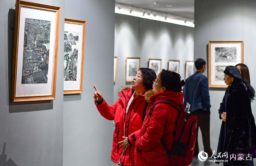 觀眾在鄂爾多斯市文化館觀賞陜西安康木板畫展。王正攝